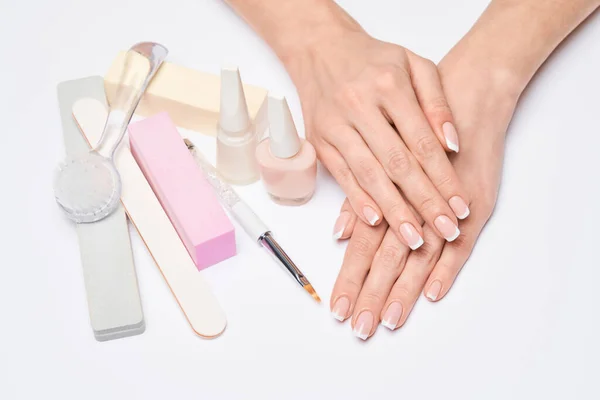 Mooie vrouwelijke handen met Franse manicure over lichtgrijze achtergrond — Stockfoto