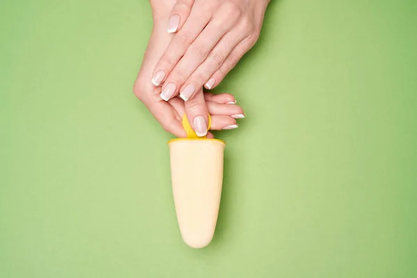 Bela fêmea bem tratada Mãos com manicure francês sobre fundo verde — Fotografia de Stock