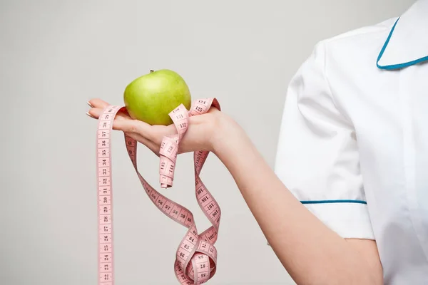 Nutricionista médico concepto de estilo de vida saludable - la celebración orgánica manzana verde fresca y cinta métrica —  Fotos de Stock