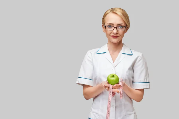 Nutricionista médico conceito de estilo de vida saudável - segurando maçã verde fresca orgânica e fita métrica — Fotografia de Stock