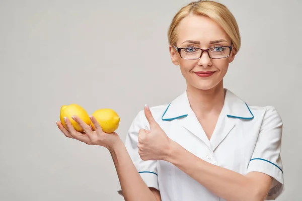 Nutricionista médico conceito de estilo de vida saudável - segurando fruta de limão orgânica — Fotografia de Stock