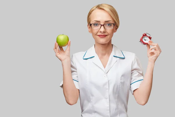 Nutricionista médico conceito de estilo de vida saudável - segurando maçã verde fresca orgânica e despertador — Fotografia de Stock