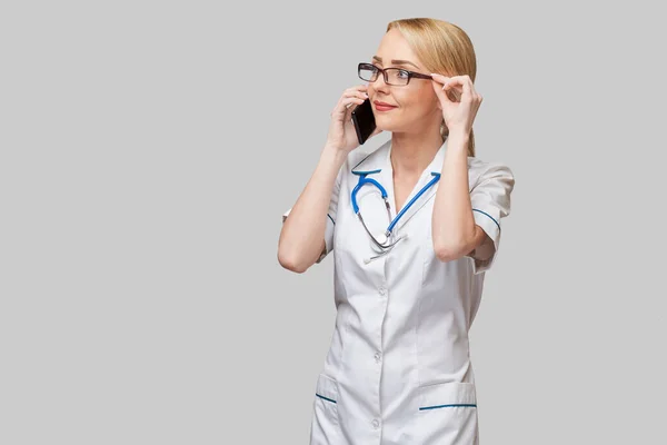 Portrait of a female doctor or nurse talking on the mobile phone — Stock Photo, Image