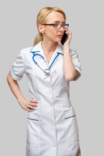 Retrato de uma médica ou enfermeira a falar no telemóvel — Fotografia de Stock