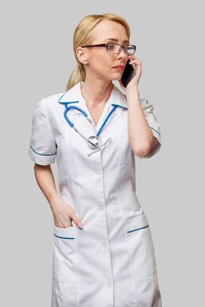 Портрет жінки-лікаря або медсестри, що розмовляє по мобільному телефону — стокове фото
