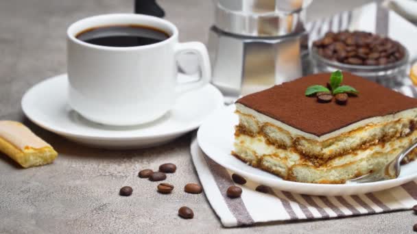 Portion traditionelles italienisches Tiramisu-Dessert und Tasse Kaffee auf grauem Betongrund — Stockvideo