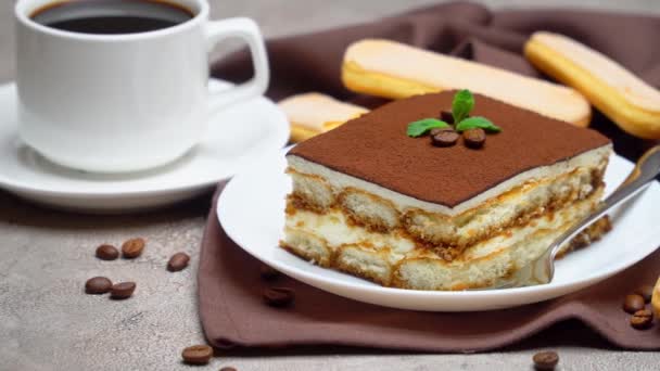 Portion traditionelles italienisches Tiramisu-Dessert und Tasse Kaffee auf grauem Betongrund — Stockvideo