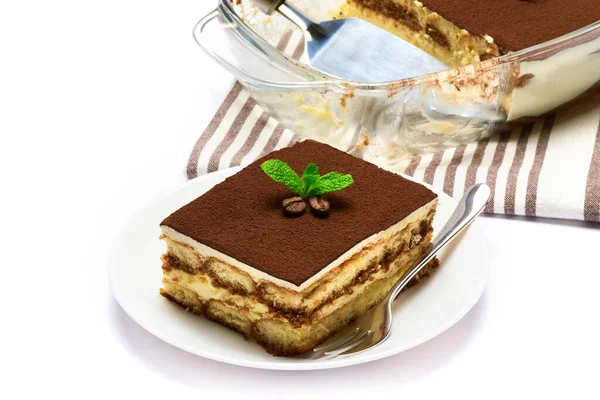 Dessert italien traditionnel Tiramisu dans un plat de cuisson en verre, portion sur assiette et omoplate isolée sur fond blanc — Photo