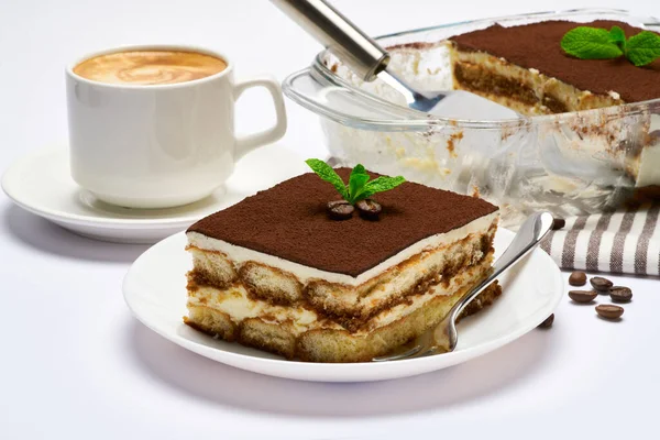 Traditionelles italienisches Tiramisu-Dessert in Glasauflaufform, Portion auf Teller und Tasse Kaffee isoliert auf weißem Hintergrund — Stockfoto