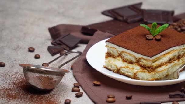 Porzione di tradizionale Tiramisù italiano dessert e chicchi di caffè su sfondo grigio cemento — Video Stock