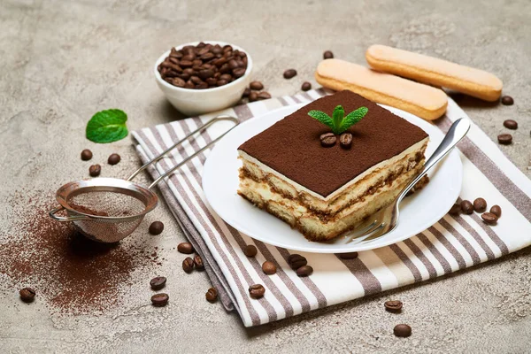 Portion de dessert Tiramisu italien traditionnel et grains de café sur fond de béton gris — Photo