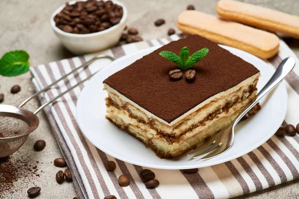Porcja tradycyjnego włoskiego deseru Tiramisu i ziarna kawy na szarym betonowym tle — Zdjęcie stockowe