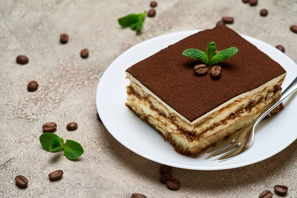 Portion traditionelles italienisches Tiramisu-Dessert und Kaffeebohnen auf grauem Betongrund — Stockfoto