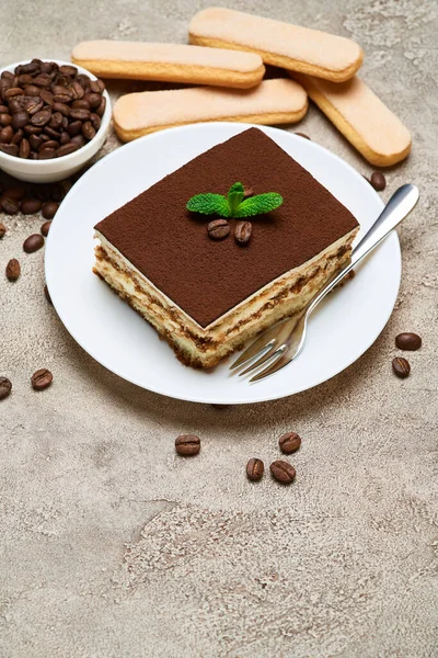 Порція традиційного італійського тирамісу десерт і кавові боби на сірому бетонному тлі — стокове фото