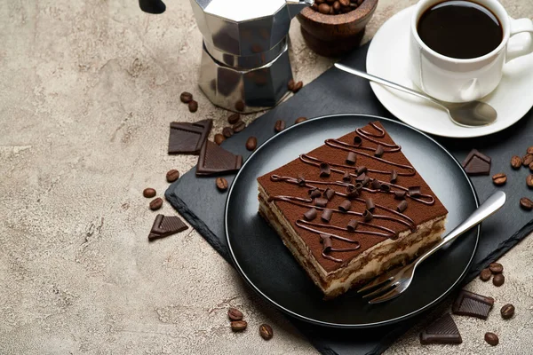 Porcja tradycyjnego włoskiego deseru Tiramisu i mocha ekspres do kawy na szarym tle betonu — Zdjęcie stockowe