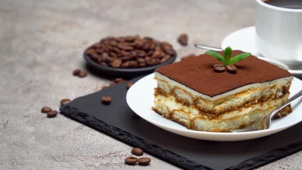 Parte da sobremesa tradicional italiana Tiramisu e xícara de café em fundo de concreto cinza — Vídeo de Stock