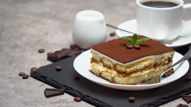 Porzione di tradizionale Tiramisù italiano dessert e tazza di caffè su sfondo grigio cemento — Video Stock