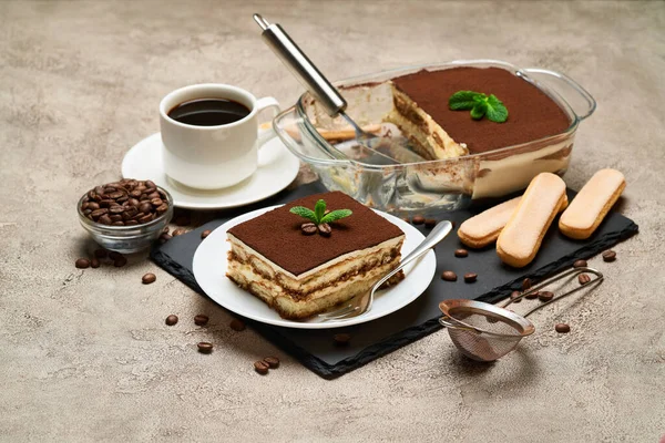 Portion traditionelles italienisches Tiramisu-Dessert und Mokkakaffeemaschine auf grauem Betongrund — Stockfoto