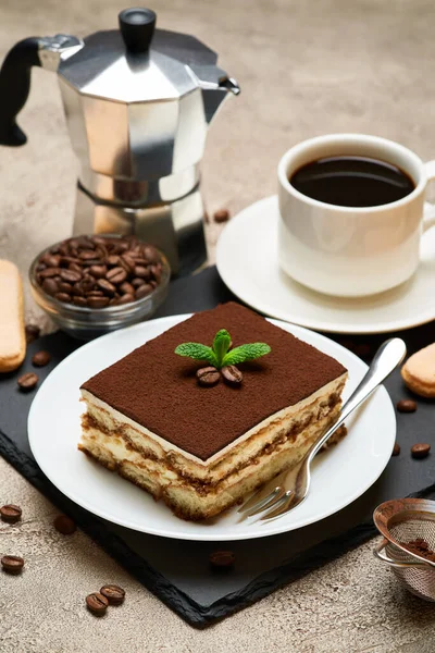 Porcja tradycyjnego włoskiego deseru Tiramisu i mocha ekspres do kawy na szarym tle betonu — Zdjęcie stockowe