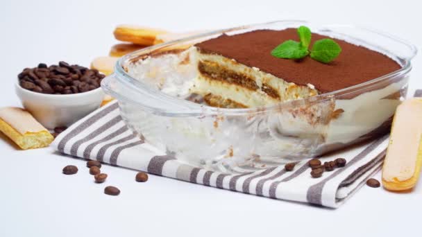 Tradycyjny włoski deser Tiramisu w szklanym naczyniu do pieczenia na białym tle — Wideo stockowe