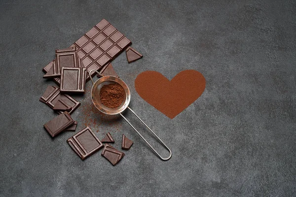 Barra di cioccolato e cacao in polvere su sfondo di cemento scuro — Foto Stock