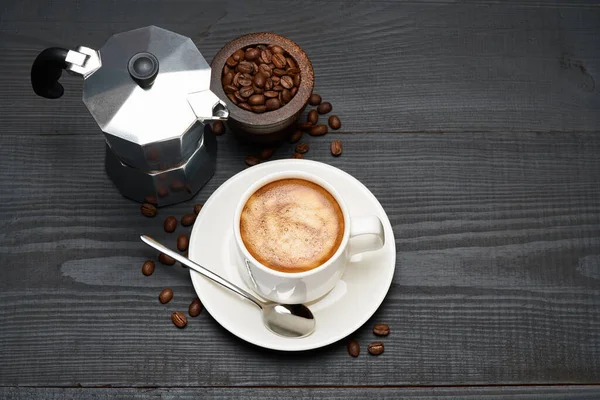 Šálek kávy espresso a moka kávovar na tmavém dřevěném pozadí — Stock fotografie