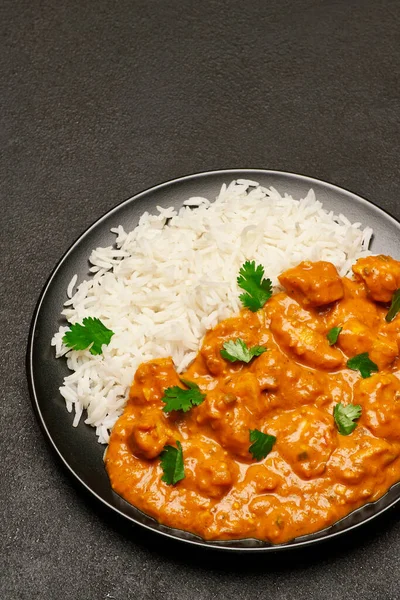 Teller mit traditionellem Chicken Curry und Reis auf dunklem Betongrund — Stockfoto