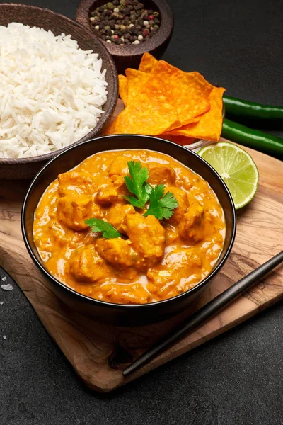 Teller mit traditionellem Chicken Curry, Reis und Gewürzen auf dunklem Betongrund — Stockfoto