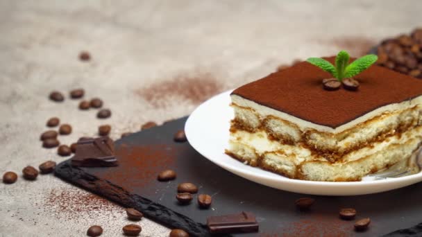 Porcja tradycyjnego włoskiego deseru Tiramisu na szarym betonowym tle — Wideo stockowe