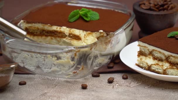 Portion of Traditional Italian Tiramisu dessert, cup of espresso and baking dish — Stock Video