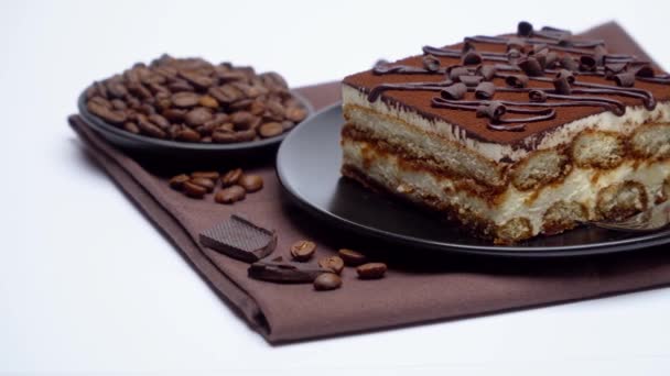 Porzione di tradizionale Tiramisù italiano dessert e chicchi di caffè su sfondo bianco — Video Stock