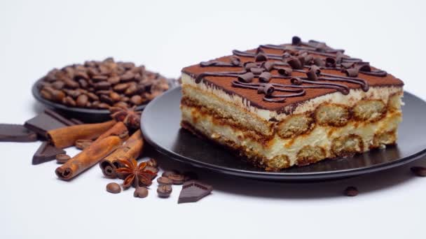 Portie traditionele Italiaanse Tiramisu dessert en koffiebonen op witte achtergrond — Stockvideo