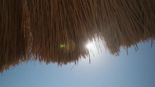 Ein Strohschirm an einem schönen Strand — Stockvideo