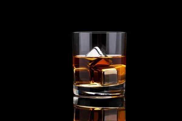 Whisky met stalen koelblokjes op donkere glazen ondergrond — Stockfoto