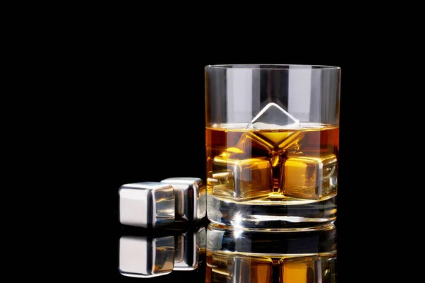 Whisky met stalen koelblokjes op donkere glazen ondergrond — Stockfoto