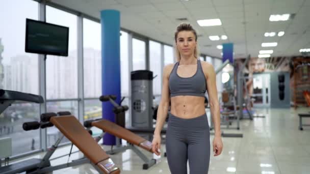 Tornatermi nő áll a fitneszgépek belül fitneszközpont — Stock videók