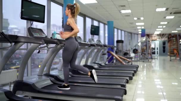 Spor salonunda koşan genç bayan. — Stok video