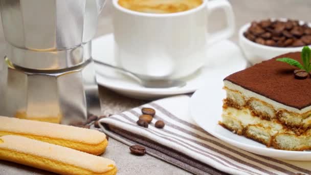 Portie traditioneel Italiaans Tiramisu dessert, mokka koffiezetapparaat, kopje espresso — Stockvideo