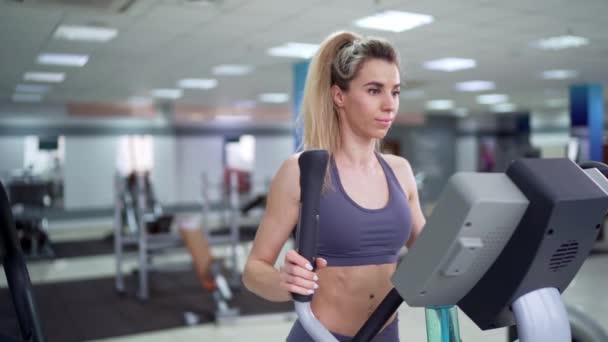 Junge Frau trainiert im Fitnessstudio auf Orbi-Bahn — Stockvideo