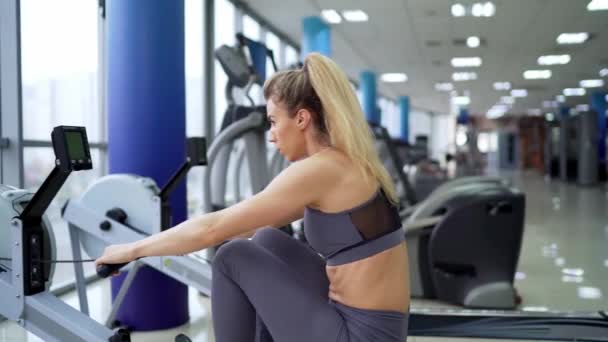 Mladá žena pracuje na řadě stroje v tělocvičně cvičení — Stock video