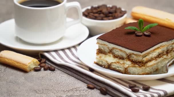 Egy adag hagyományos olasz Tiramisu desszert, egy csésze eszpresszó és kávébab. — Stock videók