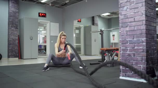 Jovem mulher esportiva trabalhando com cordas de luta Fitness no ginásio — Vídeo de Stock