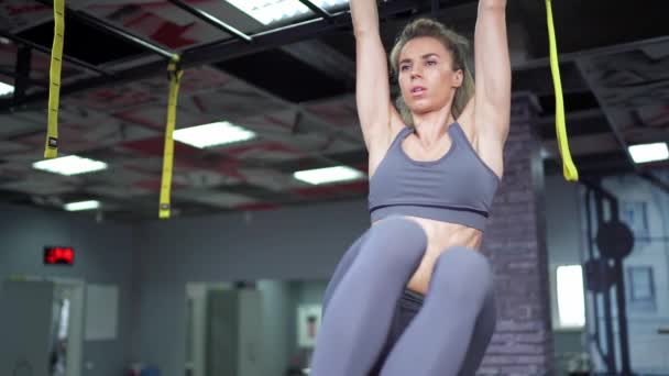 Jovem bela mulher fazendo exercício de fitness treinamento abdominal no clube de fitness — Vídeo de Stock