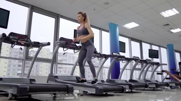Mladá sportovní žena na běžící stroj v tělocvičně — Stock video