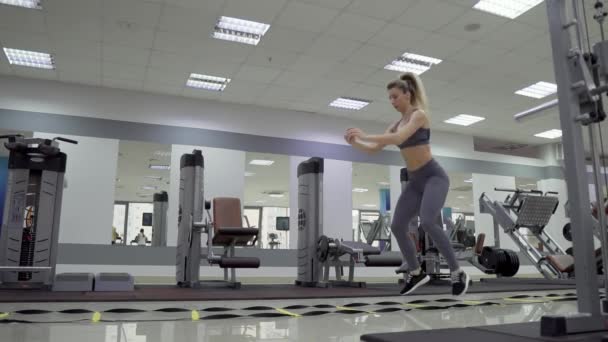 Genç kadın spor salonunda atlama egzersizi yapıyor. — Stok video