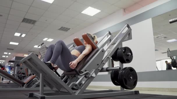 Formda kadın egzersiz makinesinde çömelme egzersizi yapıyor. — Stok video