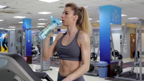 Jovem desportivo mulher no correndo máquina no ginásio beber água — Vídeo de Stock