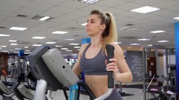 Junge Frau trainiert im Fitnessstudio auf Orbi-Bahn — Stockvideo