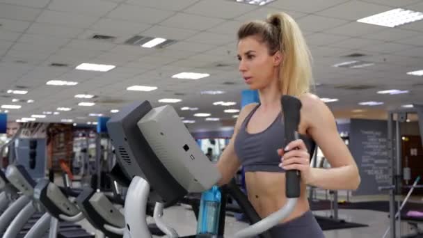 Junge Frau trainiert im Fitnessstudio auf Orbi-Bahn — Stockvideo