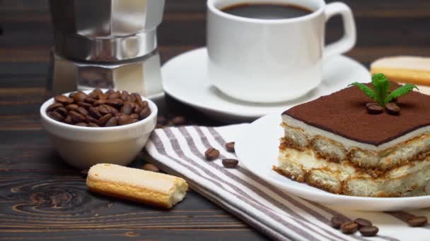 Egy adag hagyományos olasz Tiramisu desszert, egy csésze eszpresszó, mokka és kávébab. — Stock videók